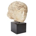 A marble female head After the Antique Her hair swept back from her forehead in waves, then drawn