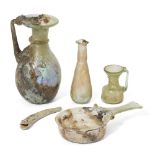 Four Roman glass vessels, circa 2nd-4th Century A.D. Including a small pale green glass skillet,