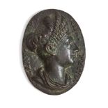 A bronze oval medallion After The Antique With the bust of a Roman lady of high birth, with ornately