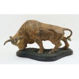 A bronze model of a bull, 20th century, on naturalistic shaped base and ebonised plinth, 29cm