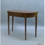 A George III mahogany fold over tea table, boxwood strung, with shell patera inlay to frieze, raised