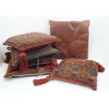 A group of four Ottoman / Afghan cushions, converted from rugs and a camel bag, 43 x 41cm and