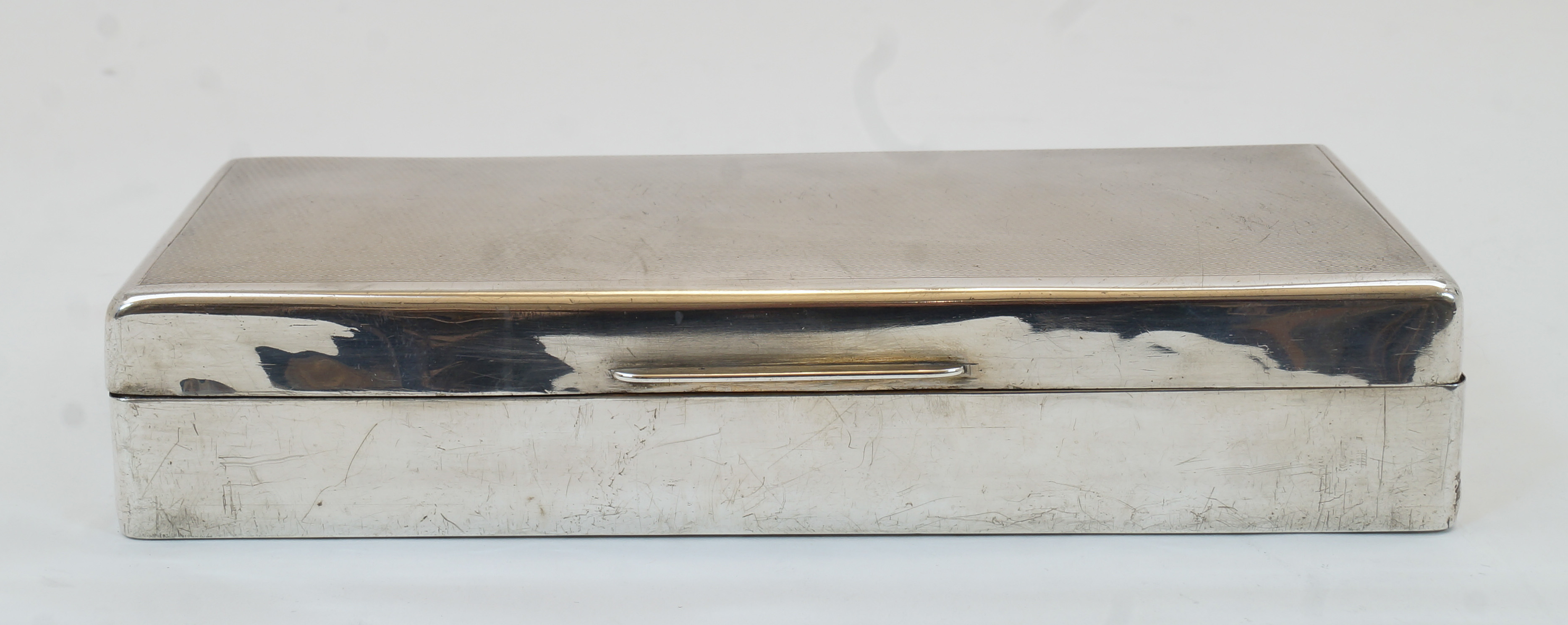 A George VI silver cigarette box, London, 1943, S J Rose & Son, of rectangular form with engine