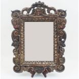 An Italian style carved oak mirror, early 20th century, the rectangular plate within a floral scroll