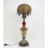 A large table lamp, 20th century, three bulb with domed filigree white metal shade and red cut glass