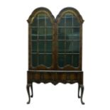 A Queen Anne style walnut twin arched display cabinet, early 20th century, with two glazed doors