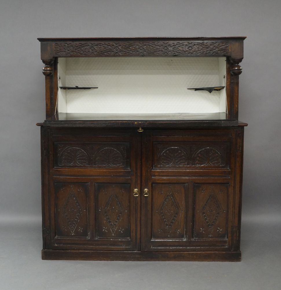 An oak court cupboard, 18th century and later, the carved frieze above carved fall front enclosing - Image 2 of 3