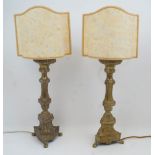 A pair of brass candlestick table lamps, 20th century, of columnar form with tripod legs and claw