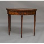 A George III mahogany bow front card table, raised on square tapering legs to spade feet, 74cm high,