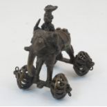 An African bronze toy of an elephant, 20th century, modelled standing on two axles supporting a