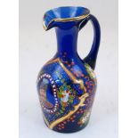 A Bohemian blue glass jug, 19th century, the body enamelled and gilded with foliate motifs and