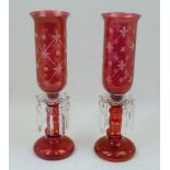 A pair of cranberry glass lustre candlestick lamps, 20th century, with clear glass sconces and