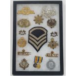 A glazed case of various militaria items, to include: miniature WWI war and victory medals, cap