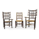 A near pair of oak wing back armchairs, 18th century, with turned spindle back rests and rush seats,