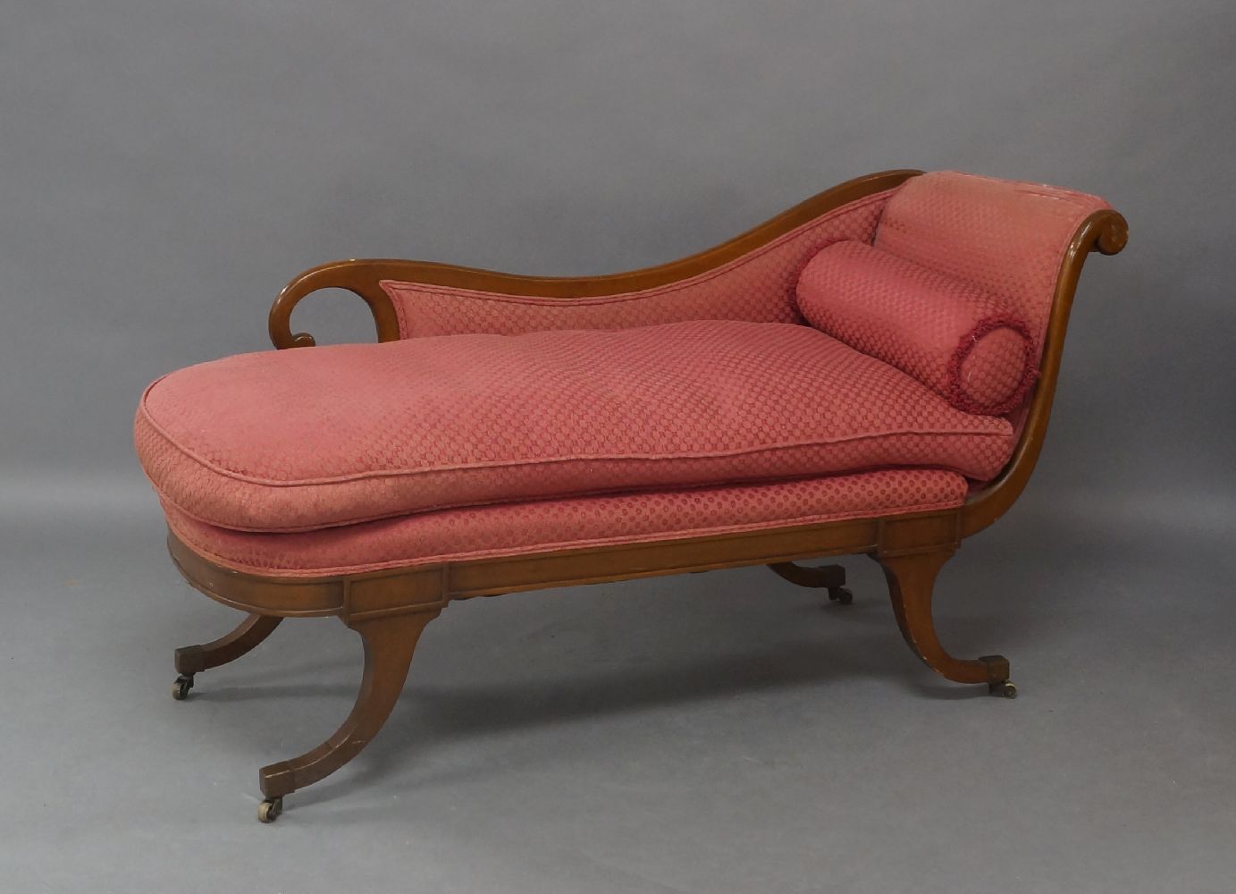 A Regency style mahogany chaise lounge, late 19th/early 20th century, with scrolling ends, raised on