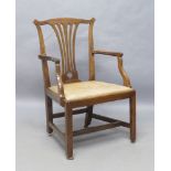 A George III walnut armchair, leather drop in seat, raised on square legs and castors, joined by