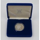 A Royal Mint Diana Princess of Wales silver proof memorial five pound coin, held within a blue