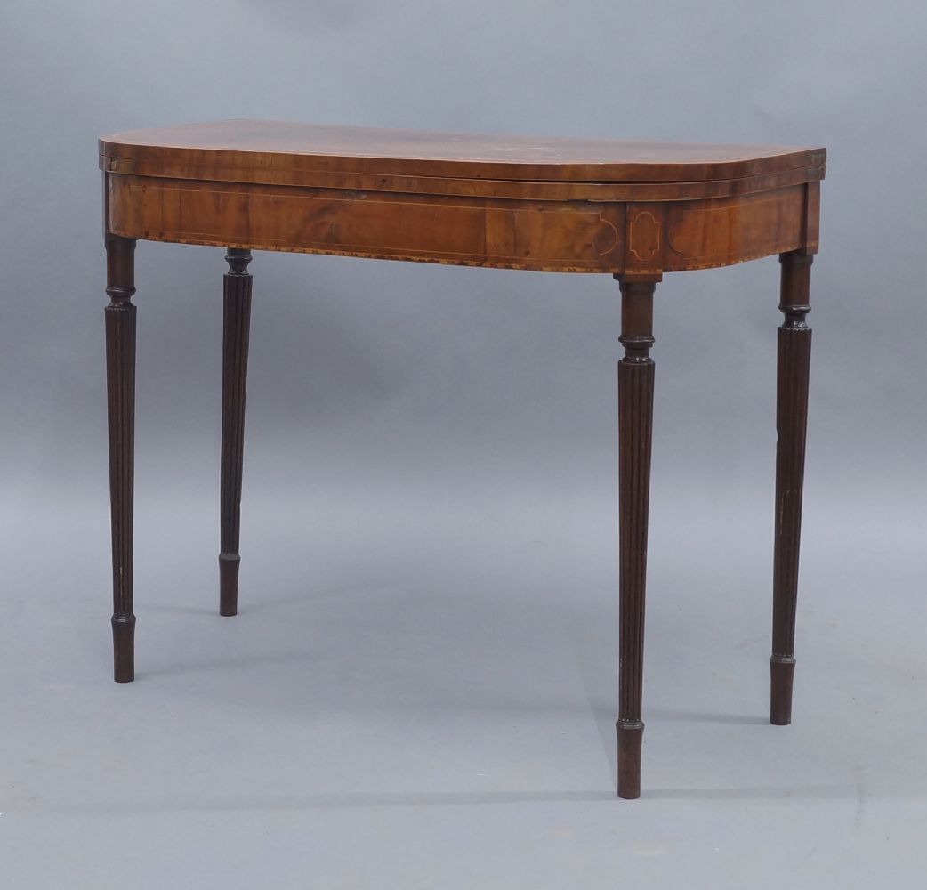 A George III mahogany card table, boxwood inlaid, raised on reeded tapered legs, 73cm high, 92cm