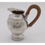 A small Continental white metal jug, probably Italian, early 19th century, of ovoid form with two