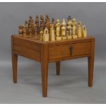 A Peruvian hardwood chess table and set, the removable top with baise lining to reverse, having