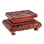 A Japanese red lacquer rectangular stand, Meiji period, carved with leafy peony flowers, 15cm wide