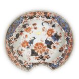 A Chinese Imari barber's bowl, 18th century, painted with flowers within an elaborate panelled