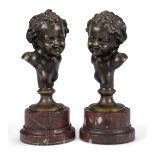 A pair of French bronze busts of children, late 19th century, each on a rouge griotte marble plinth,