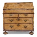 A Queen Anne walnut bureau, the fall front enclosing arrangement of pigeon holes and drawers,