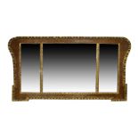 A George II walnut and parcel gilt triple plate mirror, the shaped frame with egg and dart border,