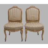 A pair of Louis XV style giltwood hall chairs, 20th century, studded silk upholstery, raised on