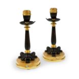 A pair of French gilt and patinated bronze candlesticks, late 19th century, each with urn sconce