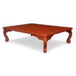 A Chinese red lacquered low coffee table, late 20th century, the rectangular top on short