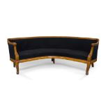 A Biedermeier style birch curved sofa, early 20th century, with black velour upholstery, raised on