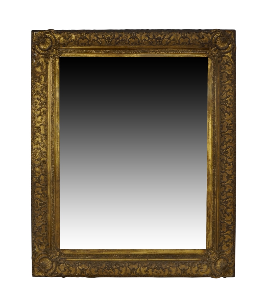 An early Victorian giltwood and gesso mirror, the C-scroll frame with shell carved corners, set with