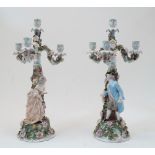 A pair of Sitzendorf figural four-light candelabra, blue underglaze marks, each modelled with a