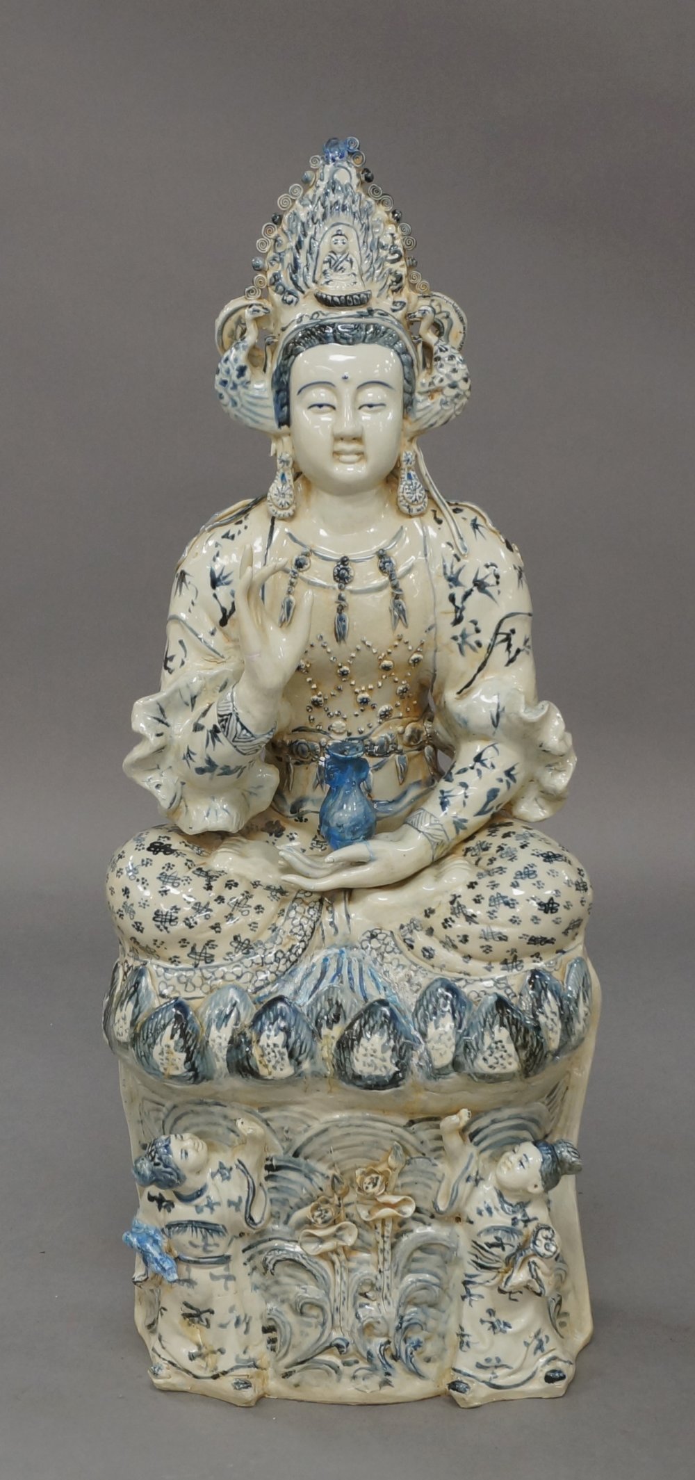 A large Chinese porcelain blue and white figure of Guanyin, 20th century, seated cross-legged on a