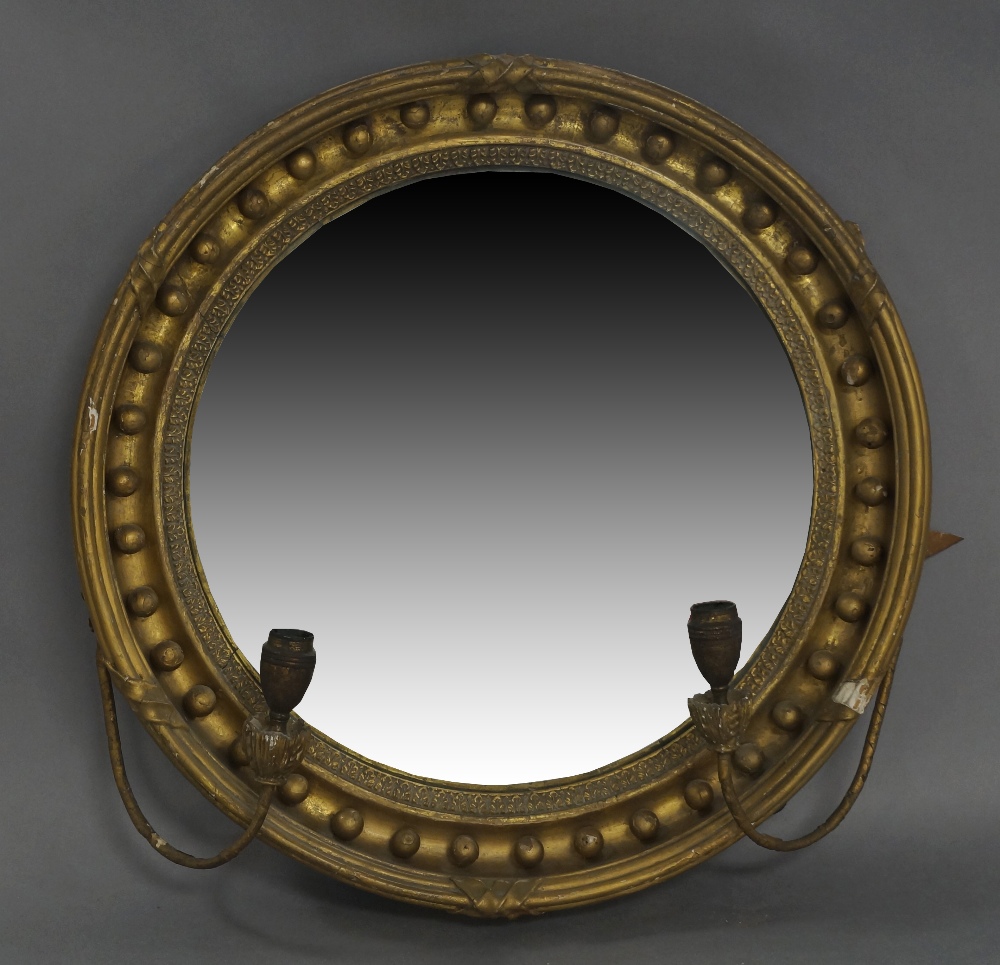 A giltwood and gesso convex mirror, 19th century, with later added candle sconces, 46cm