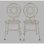 A set of four wrought iron garden chairs, 20th century, white paintedsome loss of paint