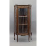 A French mahogany bow front vitrine, early 20th century, the brass gallery top inset with marble,