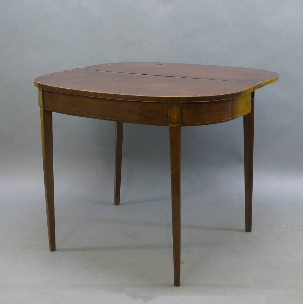 A George III mahogany fold over tea table, boxwood strung, with shell patera inlay to frieze, raised