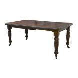 A late Victorian mahogany wind out dining table, with one extra leaf, raised on turned legs and