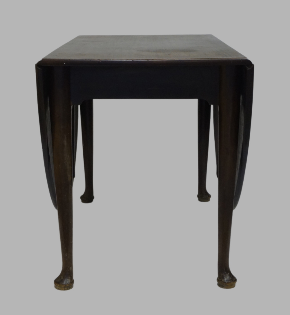 A mahogany drop leaf dining table, 19th century, raised on cylindrical tapering supports to pad
