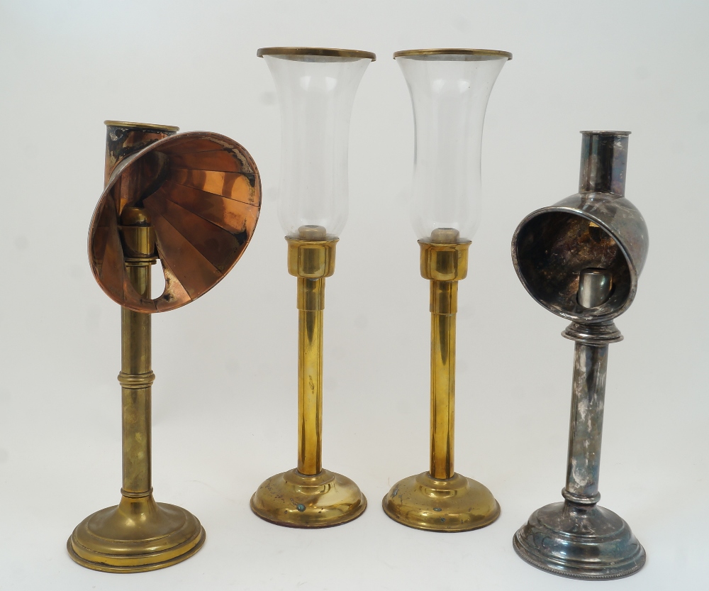 A group of four spring-loaded candlesticks, to include a late Victorian brass student's