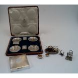 A cased set of four silver ashtrays and three matchbox covers, one matchbox cover missing, London,