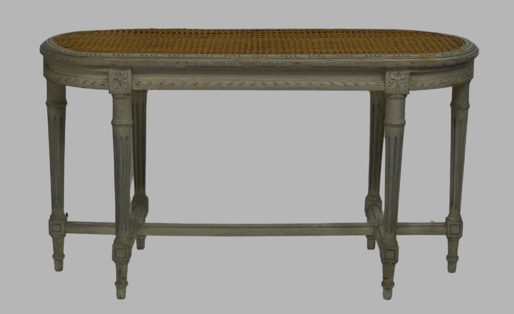 A French grey painted caned window stool, early 20th century, raised on fluted supports, joined by