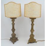 A pair of brass candlestick table lamps, 20th century, of columnar form with tripod legs and claw