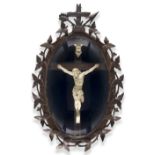 A Swiss Black Forest carved wood and meerschaum Corpus Christi, c.1920, the oval glazed frame with
