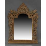 A South East Asian limed teak mirror, 20th century, the border carved and pierced with flora and