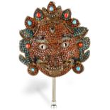 A Tibetan copper filigree and repoussé mask of Mahakala, 18th/19th century, the face inlaid with
