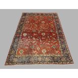 A Persian Sarouk carpet, the central field with floral and zoomorphic motifs, on a rouge ground,